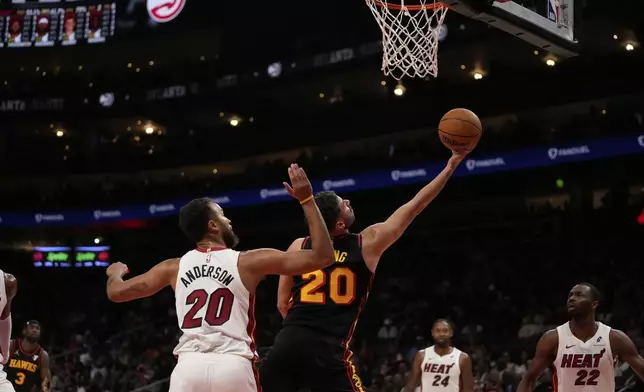 Atlanta Hawks forward Georges Niang (20) shoots against Miami Heat forward Kyle Anderson (20) in the first half of an NBA play-in tournament basketball game, Friday, April 18, 2025, in Atlanta. (AP Photo/Brynn Anderson)