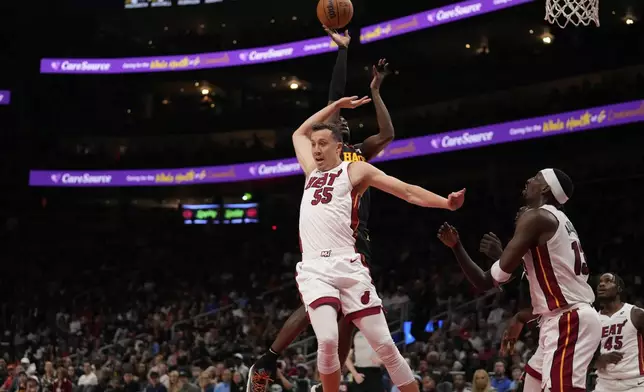 Miami Heat forward Duncan Robinson (55) attempts to block the ball against in the first half of an NBA play-in tournament basketball game against the Friday, April 18, 2025, in Atlanta. (AP Photo/Brynn Anderson)