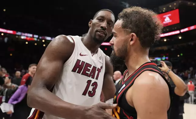 Miami Heat center Bam Adebayo (13) and Atlanta Hawks guard Trae Young (11) meet after an NBA play-in tournament basketball game, Friday, April 18, 2025, in Atlanta. (AP Photo/Brynn Anderson)