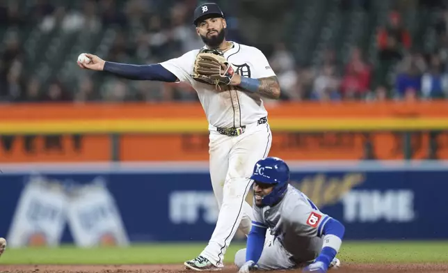 Detroit Tigers second baseman Gleyber Torres throws to first base to complete a double play as Kansas City Royals' Maikel Garcia slides into second base late in the eighth inning during a baseball game, Thursday, April 17, 2025, in Detroit. (AP Photo/Paul Sancya)