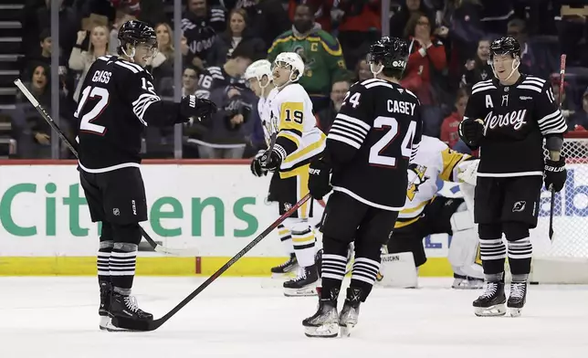 New Jersey Devils left wing Ondrej Palat, right, celebrates after scoring a goal with Seamus Casey (24) and Cody Glass (12) in the first period of an NHL hockey game against the Pittsburgh Penguins, Friday, April 11, 2025, in Newark, N.J. (AP Photo/Adam Hunger)