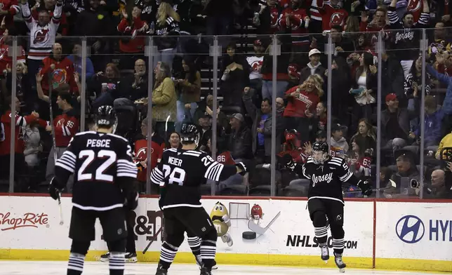New Jersey Devils left wing Erik Haula, right, celebrates toward teammates after scoring a goal in the first period of an NHL hockey game against the Pittsburgh Penguins, Friday, April 11, 2025, in Newark, N.J. (AP Photo/Adam Hunger)
