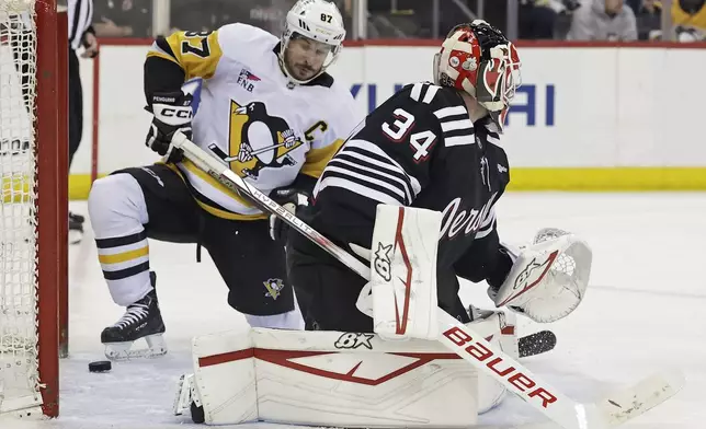 Pittsburgh Penguins center Sidney Crosby (87) scores a goal past New Jersey Devils goaltender Jake Allen in the third period of an NHL hockey game Friday, April 11, 2025, in Newark, N.J. (AP Photo/Adam Hunger)