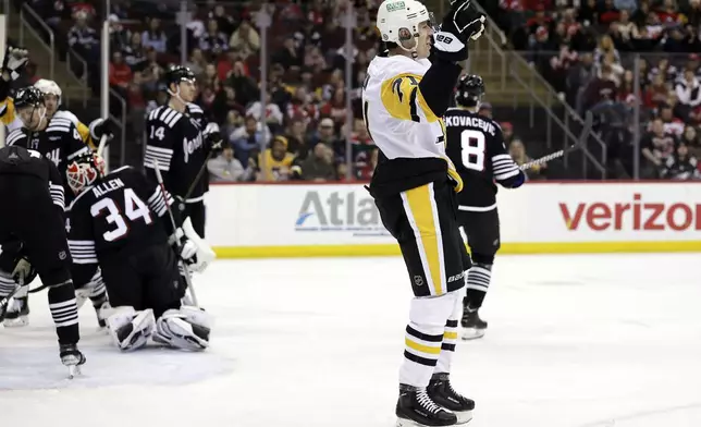 Pittsburgh Penguins center Evgeni Malkin (71) reacts after scoring past New Jersey Devils goaltender Jake Allen (34) in the first period of an NHL hockey game Friday, April 11, 2025, in Newark, N.J. (AP Photo/Adam Hunger)