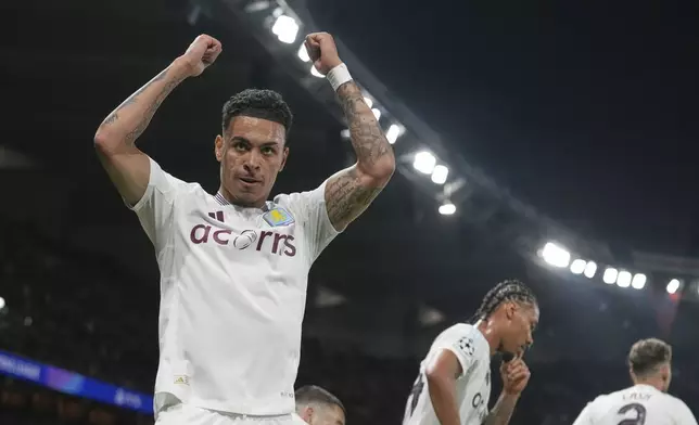 Aston Villa's Morgan Rogers, left, celebrates after scoring his side's opening goal during the Champions League quarterfinal first leg soccer match between Paris Saint-Germain and Aston Villa at Parc des Princes stadium in Paris, Wednesday, April 9, 2025. (AP Photo/Thibault Camus)