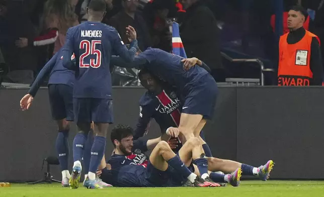 PSG's Khvicha Kvaratskhelia, on the ground, celebrates after scoring his side's second goal during the Champions League quarterfinal first leg soccer match between Paris Saint-Germain and Aston Villa at Parc des Princes stadium in Paris, Wednesday, April 9, 2025. (AP Photo/Aurelien Morissard)