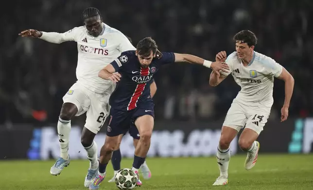 PSG's Khvicha Kvaratskhelia, centre, challenges for the ball with Aston Villa's Amadou Onana, left, and Aston Villa's Pau Torres, right, during the Champions League quarterfinal first leg soccer match between Paris Saint-Germain and Aston Villa at Parc des Princes stadium in Paris, Wednesday, April 9, 2025. (AP Photo/Thibault Camus)