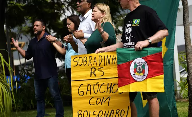 Supporters of former President Jair Bolsonaro pray outside DF Star hospital where he had abdominal surgery in Brasilia, Brazil, Monday, April 14, 2025. (AP Photo/Eraldo Peres)