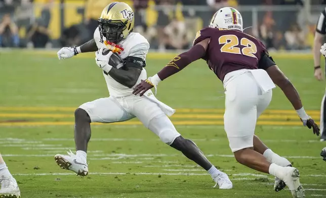FILE - Central Florida running back Myles Montgomery, left, finds running room against Arizona State linebacker Caleb McCullough (22) during the first half of an NCAA college football game Saturday, Nov. 9, 2024, in Tempe, Ariz. (AP Photo/Darryl Webb, File)