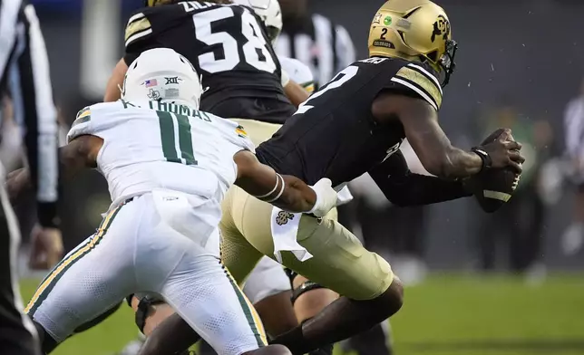 FILE - Baylor linebacker Keaton Thomas, left, pursues Colorado quarterback Shedeur Sanders, right, in the first half of an NCAA college football game Saturday, Sept. 21, 2024, in Boulder, Colo. (AP Photo/David Zalubowski, File)