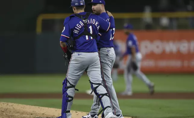 Texas Rangers pitcher Luke Jackson, right, and catcher Kyle Higashioka, left, celebrate after their victory against the Athletics after a baseball game Tuesday, April 22, 2025, in West Sacramento, Calif. (AP Photo/Scott Marshall)