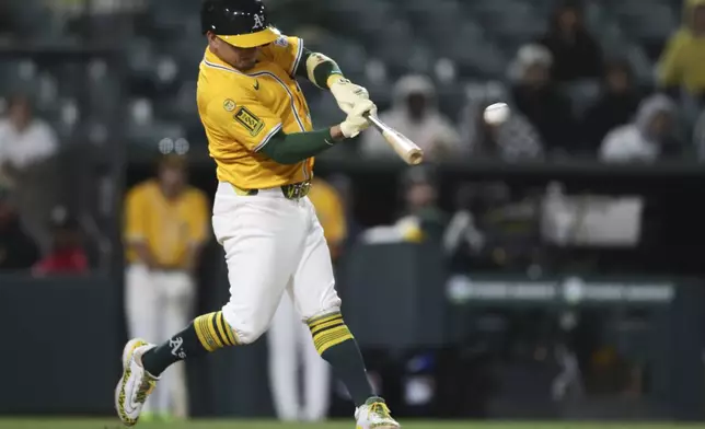 Athletics Luis Urías (17) hits a solo home run against the Texas Rangers during the eighth inning of a baseball game Tuesday, April 22, 2025, in West Sacramento, Calif. (AP Photo/Scott Marshall)