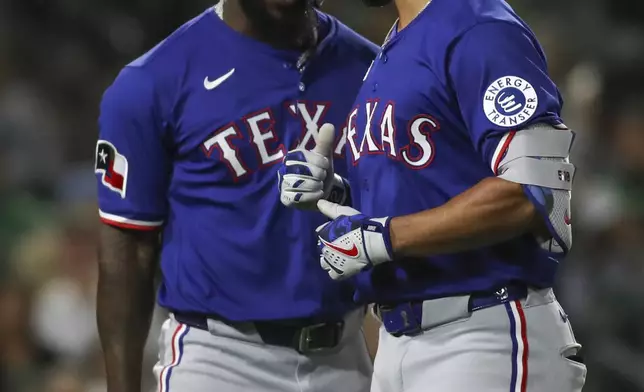 Texas Rangers' Marcus Semien, right, celebrates with teammate Adolis García (53) after hitting a three-run home run against the Athletics during the fifth inning of a baseball game Tuesday, April 22, 2025, in West Sacramento, Calif. (AP Photo/Scott Marshall)