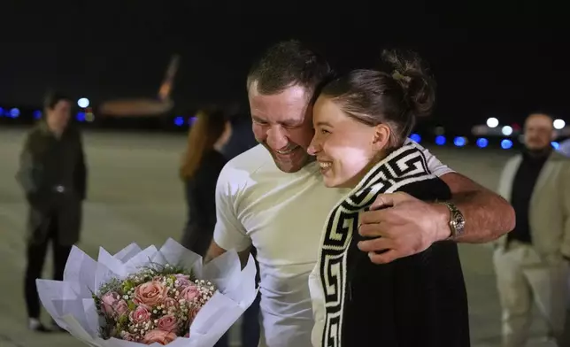 Ksenia Karelina walks with her fiancé, professional boxer Chris van Heerden, as she arrives Thursday, April 10, 2025, at Joint Base Andrews, Md. (AP Photo/Alex Brandon)