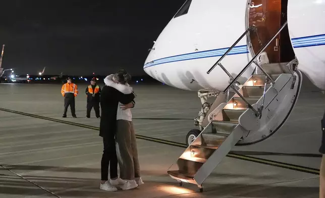 Ksenia Karelina hugs her fiancé, professional boxer Chris van Heerden, as she arrives Thursday, April 10, 2025, at Joint Base Andrews, Md. (AP Photo/Alex Brandon)