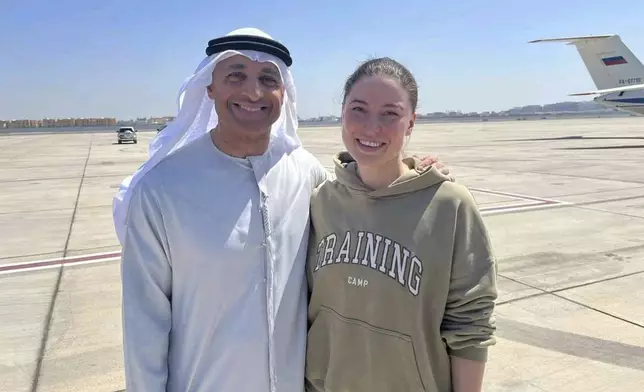 This photo released by the state-run WAM news agency shows Yousef al-Otaiba, the UAE ambassador to the U.S., left, standing next to U.S.-Russian dual national Ksenia Karelina after her release at an airport in Abu Dhabi, United Arab Emirates, Thursday, April 10, 2025. (WAM via AP)