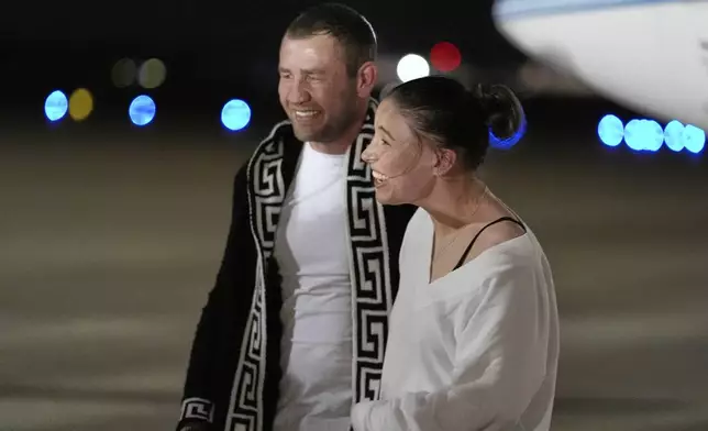 Ksenia Karelina smiles with her fiancé, professional boxer Chris van Heerden, as she arrives Thursday, April 10, 2025, at Joint Base Andrews, Md. (AP Photo/Alex Brandon)