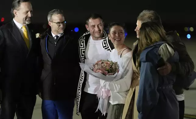 Ksenia Karelina and her fiancé, professional boxer Chris van Heerden, talks on the tarmac as she arrives Thursday, April 10, 2025, at Joint Base Andrews, Md. (AP Photo/Alex Brandon)