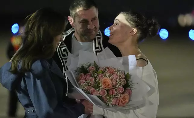 Ksenia Karelina and her fiancé, professional boxer Chris van Heerden, talk with Morgan Ortagus, deputy special presidential envoy to the Middle East, Thursday, April 10, 2025, at Joint Base Andrews, Md. (AP Photo/Alex Brandon)