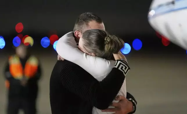 Ksenia Karelina hugs her fiancé, professional boxer Chris van Heerden, as she arrives Thursday, April 10, 2025, at Joint Base Andrews, Md. (AP Photo/Alex Brandon)