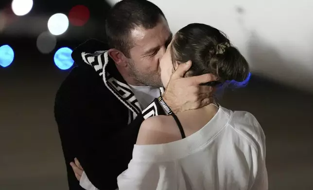 Ksenia Karelina kisses her fiancé, professional boxer Chris van Heerden, as she arrives Thursday, April 10, 2025, at Joint Base Andrews, Md. (AP Photo/Alex Brandon)
