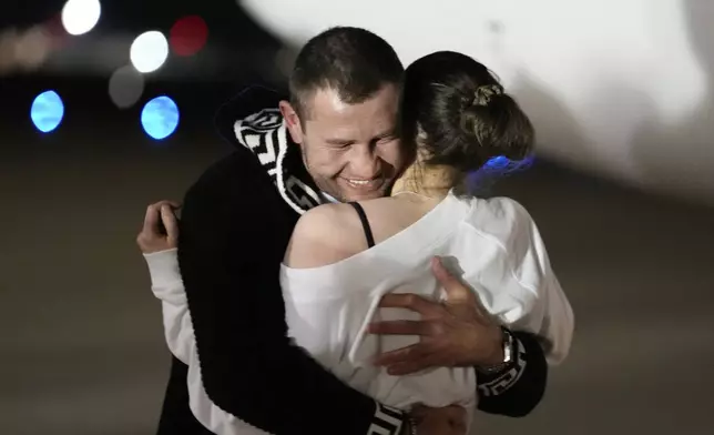 Ksenia Karelina hugs her fiancé, professional boxer Chris van Heerden, as she arrives Thursday, April 10, 2025, at Joint Base Andrews, Md. (AP Photo/Alex Brandon)