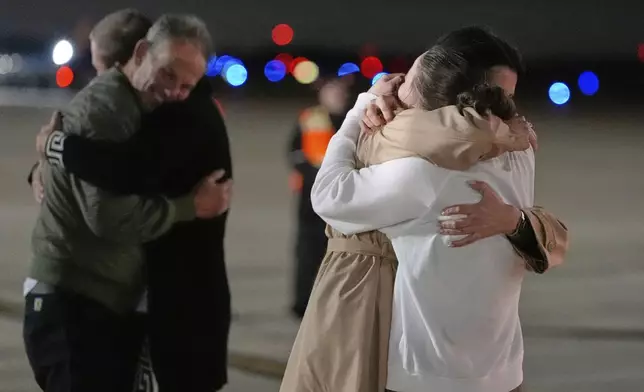 Ksenia Karelina hugs a friend, front right, as her fiancé, professional boxer Chris van Heerden, embraces another friend, far left, as she arrives Thursday, April 10, 2025, at Joint Base Andrews, Md. (AP Photo/Alex Brandon)