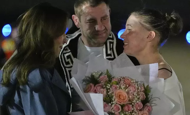 Ksenia Karelina and her fiancé, professional boxer Chris van Heerden, talks with Morgan Ortagus, deputy special presidential envoy to the Middle East, as she arrives Thursday, April 10, 2025, at Joint Base Andrews, Md. (AP Photo/Alex Brandon)
