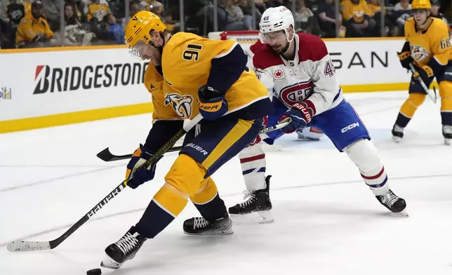 Nashville Predators center Steven Stamkos (91) and Montreal Canadiens defenseman Alexandre Carrier (45) vie for the puck during the second period of an NHL hockey game Sunday, April 6, 2025, in Nashville, Tenn. (AP Photo/Mark Humphrey)