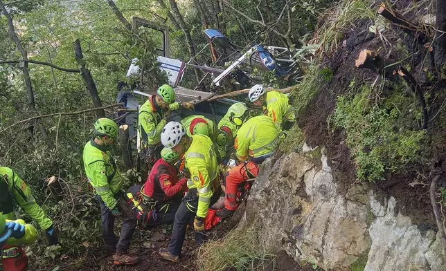 In this photo released by the Italian Alpine and Speleological Rescue Corps on Friday, April 18, 2025, rescuers reach for the smashed gondola of the Mt. Faito cablecar near Naples in southern Italy connecting Castellammare di Stabia to the top of Mt. Faito, that was carrying tourists, on Thursday when the cable snapped, killing at least four people and injuring one. (Soccorso Alpino e Speleologico via AP, HO)