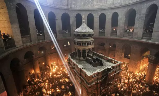 Christian pilgrims light candles during the Holy Fire ceremony, at the Church of the Holy Sepulcher, the site where according to tradition Jesus was crucified and buried, in Jerusalem's Old City, Saturday, April 19, 2025. (AP Photo/Mahmoud Illean)