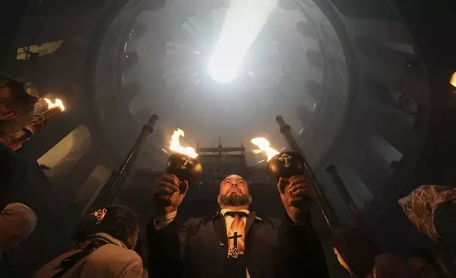 Christian pilgrims hold candles during the Holy Fire ceremony, at the Church of the Holy Sepulcher, the site where according to tradition Jesus was crucified and buried, in Jerusalem's Old City, Saturday, April 19, 2025. (AP Photo/Mahmoud Illean)