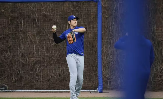 Los Angeles Dodgers' Shohei Ohtani (17) warms before a baseball game against the Chicago Cubs, Tuesday, April 22, 2025, in Chicago. (AP Photo/Erin Hooley)
