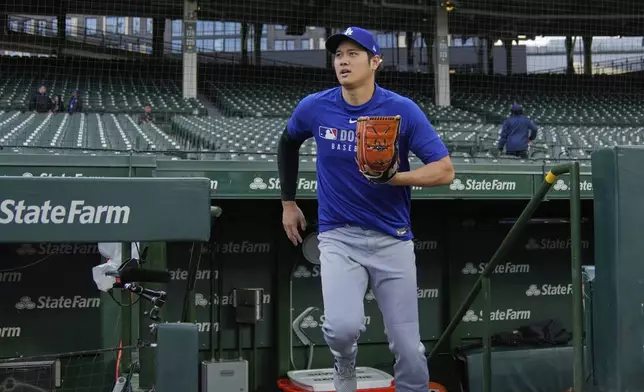 Los Angeles Dodgers' Shohei Ohtani (17) warms before a baseball game against the Chicago Cubs, Tuesday, April 22, 2025, in Chicago. (AP Photo/Erin Hooley)