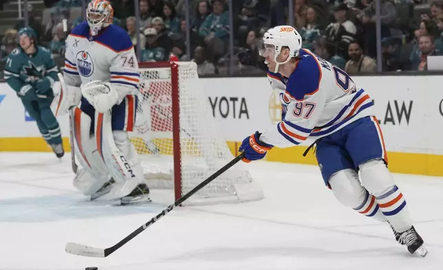 Edmonton Oilers center Connor McDavid (97) skates with the puck against the San Jose Sharks during the first period of an NHL hockey game in San Jose, Calif., Wednesday, April 16, 2025. (AP Photo/Jeff Chiu)