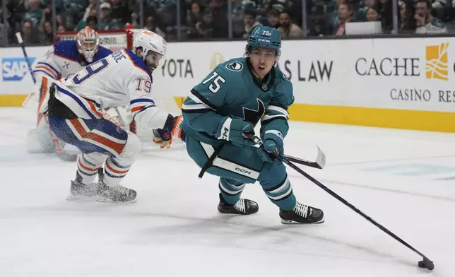 San Jose Sharks left wing Danil Gushchin (75) skates with the puck against Edmonton Oilers center Adam Henrique (19) during the first period of an NHL hockey game in San Jose, Calif., Wednesday, April 16, 2025. (AP Photo/Jeff Chiu)