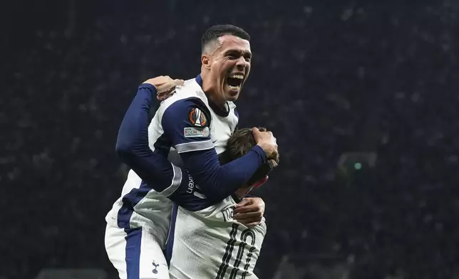 Tottenham's Pedro Porro celebrates with James Maddison after scoring his side's first goal during the Europa League quarterfinals first leg soccer match between Tottenham Hotspur and Eintracht Frankfurt at the Tottenham Hotspur Stadium in London, England, Thursday, April 10, 2025. (AP Photo/Frank Augstein)