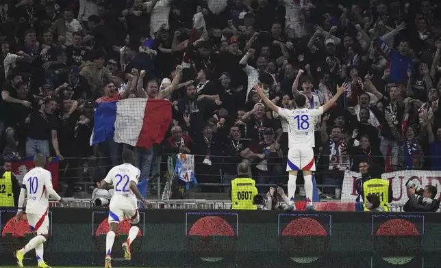Lyon's Rayan Cherki, right, celebrates with teammates after scoring his side's second goal during the Europa League quarterfinal first leg soccer match between Lyon and Manchester United at Groupama stadium in Decines, outside Lyon, France, Thursday, April 10, 2025. (AP Photo/Thibault Camus)
