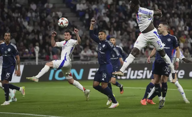 Manchester United's Casemiro, centre, challenges for the ball with Lyon's Nicolas Tagliafico, centre left, and Moussa Niakhate, centre right, as Lyon's Thiago Almada, not in the picture, scores the opening goal during the Europa League quarterfinal first leg soccer match between Lyon and Manchester United at Groupama stadium in Decines, outside Lyon, France, Thursday, April 10, 2025. (AP Photo/Thibault Camus)