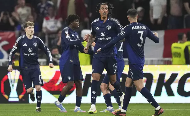 Manchester United's Leny Yoro, second from right, celebrates with teammates after scoring his side's first goal during the Europa League quarterfinal first leg soccer match between Lyon and Manchester United at Groupama stadium in Decines, outside Lyon, France, Thursday, April 10, 2025. (AP Photo/Thibault Camus)