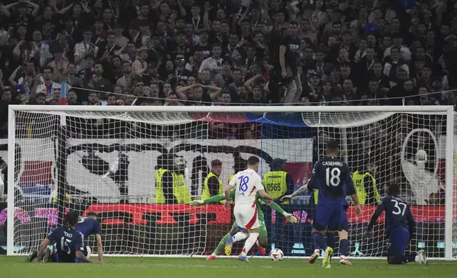Lyon's Rayan Cherki, centre back to the camera, scores his side's second goal past Manchester United's goalkeeper Andre Onana during the Europa League quarterfinal first leg soccer match between Lyon and Manchester United at Groupama stadium in Decines, outside Lyon, France, Thursday, April 10, 2025. (AP Photo/Thibault Camus)