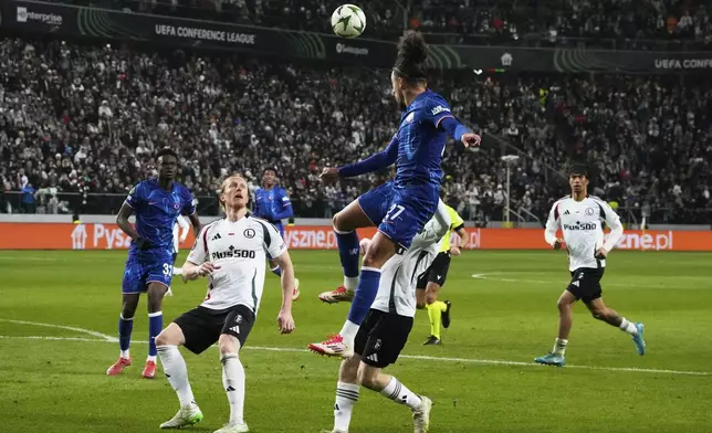 Chelsea's Malo Gusto, center, jumps for the ball during the Europa Conference League first-leg quarterfinals soccer match between Legia Warszawa and Chelsea at the Marshall Jozef Pilsudski's Municipal stadium in Warsaw, Poland, Thursday, April 10, 2025. (AP Photo/Czarek Sokolowski)