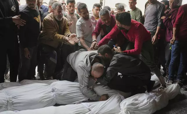 Palestinians mourn over the bodies of their relatives who were killed in an Israeli airstrike in Shijaiyah neighborhood, as they brought to the Baptist Hospital in Gaza City on Wednesday, April 9, 2025. (AP Photo/Jehad Alshrafi)