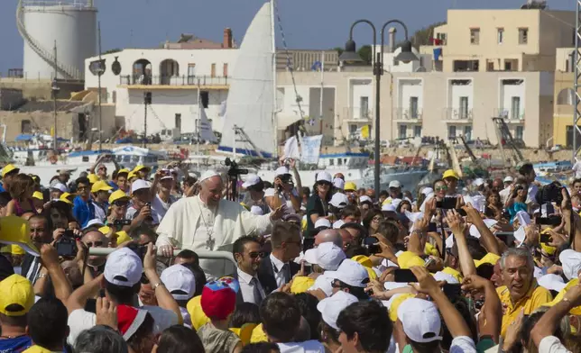 FILE - Pope Francis waves to faithful as he is driven through the crowd during his visit to the island of Lampedusa, southern Italy, Monday July 8, 2013. (AP Photo/Alessandra Tarantino, file)
