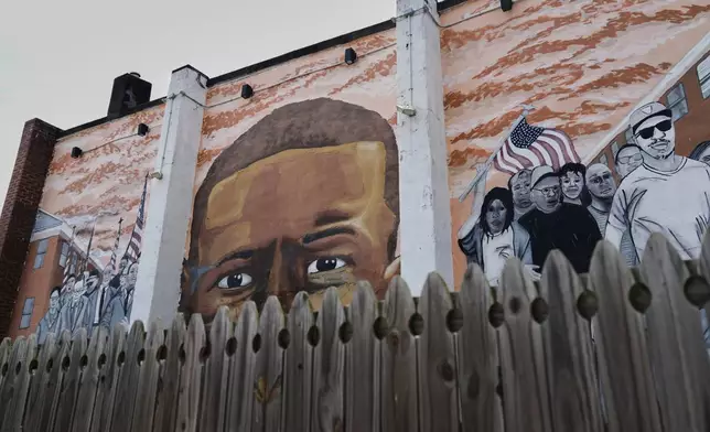 A mural dedicated to Freddie Gray is seen behind a fence, Monday, April 14, 2025, in the Sandtown-Winchester neighborhood in Baltimore, near where he was arrested before his subsequent death in 2015. (AP Photo/Stephanie Scarbrough)