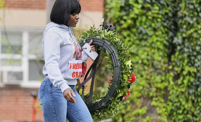 Fredricka Gray, twin sister of Freddie Gray, walks with a wreath to lay during a memorial event commemorating the ten-year anniversary of her brother's death, Saturday, April 19, 2025, in Baltimore. (AP Photo/Stephanie Scarbrough)