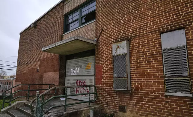 A side entrance of the vacant Lillian S. Jones Recreation Center is boarded shut and a broken window is seen, Monday, April 14, 2025, in the Sandtown-Winchester neighborhood in Baltimore. (AP Photo/Stephanie Scarbrough)