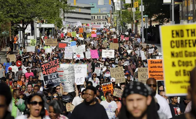 FILE - Protesters march through Baltimore the day after charges were announced against the police officers involved in Freddie Gray's death, May 2, 2015. (AP Photo/Patrick Semansky, File)