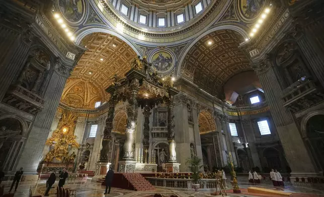 Staff make final preparations in St. Peter's Basilica ahead of the arrival of the body of Pope Francis, who will lie in state for three days, at the Vatican, Wednesday, April 23, 2025. (AP Photo/Alessandra Tarantino)