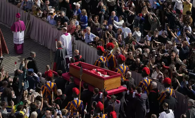 The ceremony with the Pope Francis' body, who will lie in state at St. Peter's Basilica for three days, pass through the crowd at the Vatican, Wednesday, April 23, 2025. (AP Photo/Gregorio Borgia)